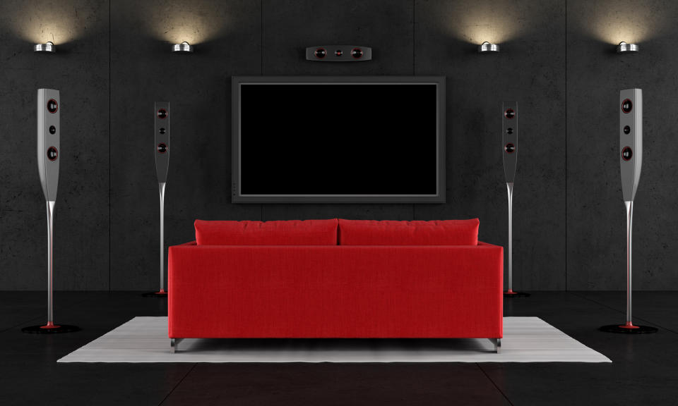 A red couch facing a TV screen in a home theater