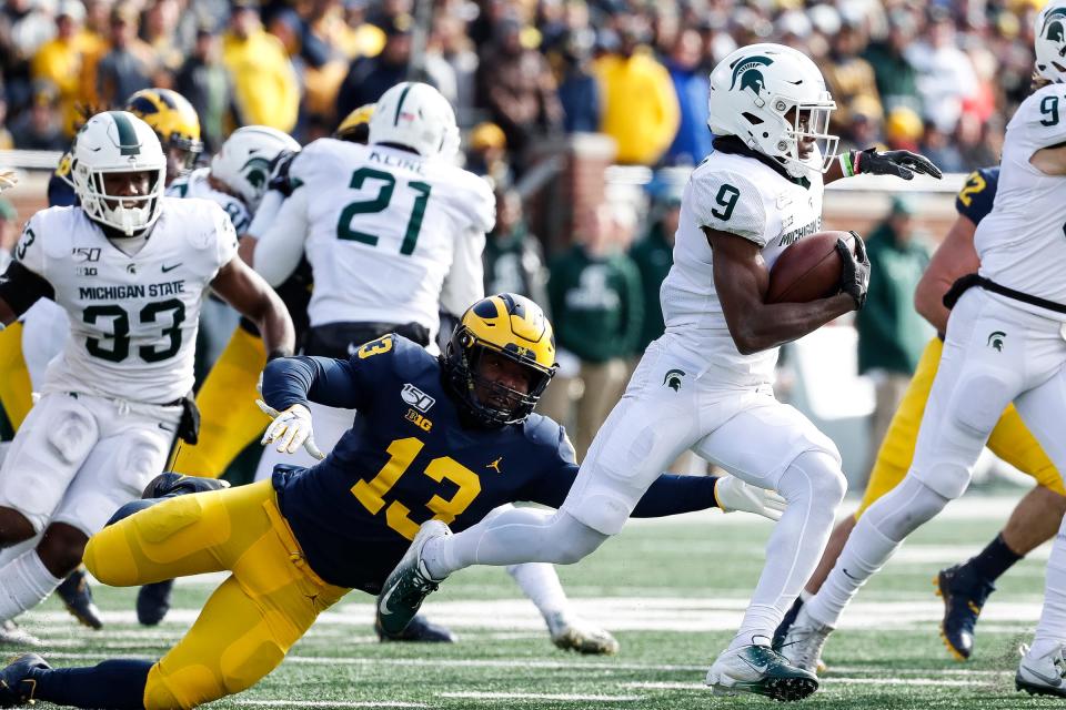 Michigan's Charles Thomas tries to stop Michigan State kick returner Anthony Williams Jr. during the first half at Michigan Stadium in Ann Arbor, Saturday, Nov. 16, 2019.