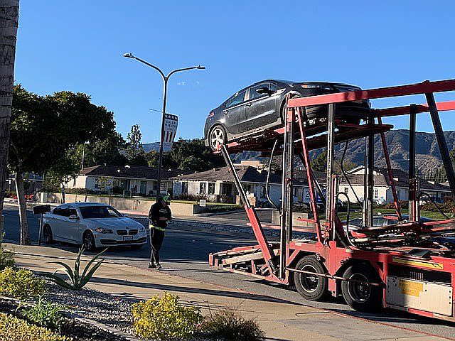 拖車司機開動機器手將汽車裝上拖車甲板，每輛汽車上車時間約需15分鐘。（記者楊青/攝影）