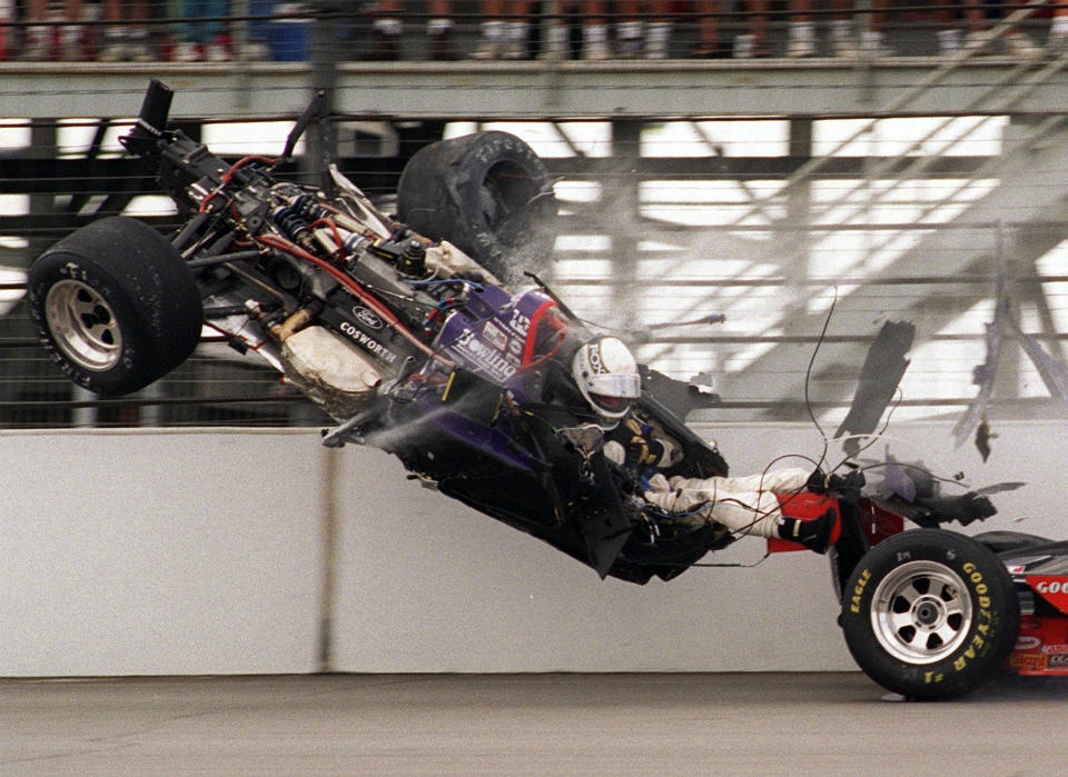 FILE - Stan Fox, his legs exposed, sits in his airborne car after the front end was torn off while slamming into the first-turn wall on the opening lap of the Indianapolis 500, May 28, 1995. Fox's car had collided with Eddie Cheever's, right, both hitting the wall. Fox's legs were uninjured, but he was hospitalized with serious head injuries. Following a deadly crash in 1973, Indianapolis Motor Speedway put a number of safeguards in place and eventually Indy car cockpits were repositioned to protect the legs and feet of drivers and tubs were made of stronger, safer materials to increase safety during the accidents that still occur. (AP Photo/Marty Seppala, File)