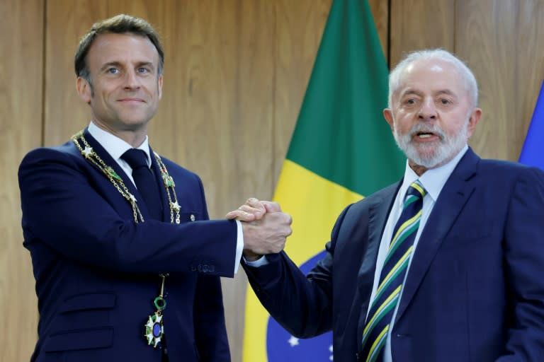 France's President Emmanuel Macron (L) wears the Order of the Southern Cross decoration while posing for a picture with Brazil's President Luiz Inacio Lula da Silva (R) at the Planalto Palace in Brasilia (Ludovic MARIN)