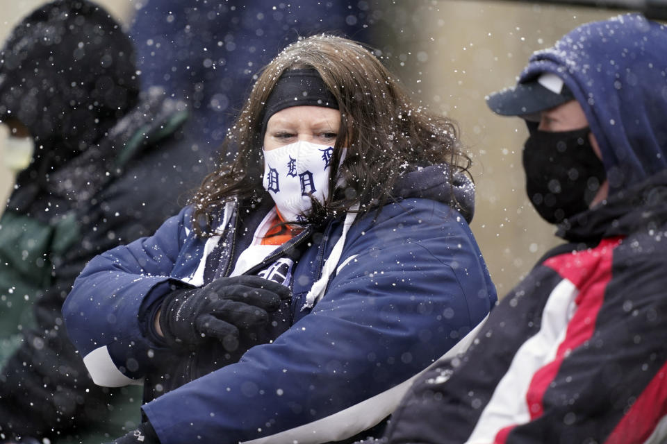 Patty and Steve Smith watch the baseball game between the Detroit Tigers and the Cleveland Indians as snow falls, Thursday, April 1, 2021, in Detroit. (AP Photo/Carlos Osorio)
