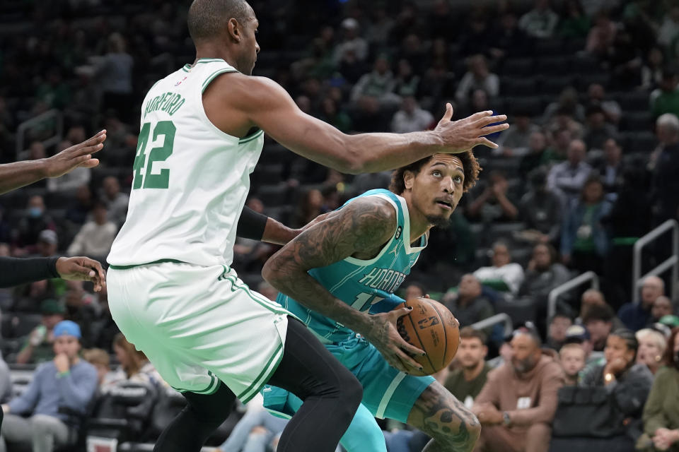 Charlotte Hornets' Kelly Oubre Jr., right, looks for an opening around Boston Celtics' Al Horford, left, in the first half of a preseason NBA basketball game, Sunday, Oct. 2, 2022, in Boston. (AP Photo/Steven Senne)