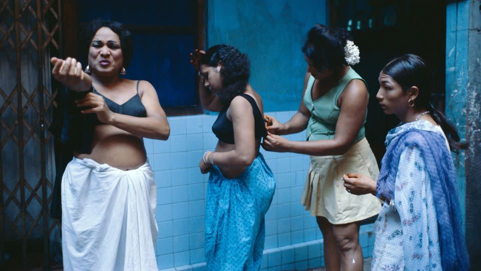 Trans sex workers getting dressed in a courtyard. - Mary Ellen Mark