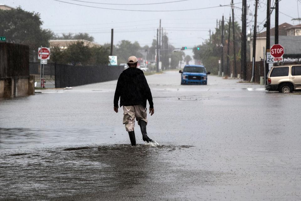 A man walks through a street flooded by Tropical Storm Beta on Monday, Sept. 21, 2020, in Galveston, Texas.