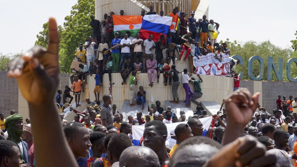 Anti-colonial and pro-Russia supporters stand outside the National Assembly building in Niamey on Sunday. - Issifou Djibo/EPA-EFE/Shutterstock