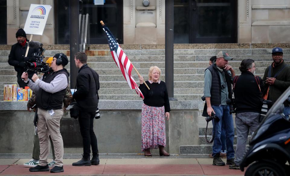 Karen Spizer, of Kenosha, holds an American flag in front of the Kenosha County Courthouse during the trial of Kyle Rittenhouse in Kenosha on Wednesday, Nov. 17.