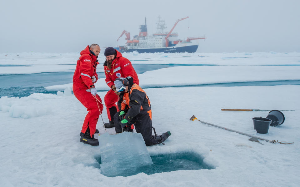 Scientists haul a sample of ice from the Arctic Ocean as part of research into the effects of climate change on the sensitive region as their vessel, the RV Polarstern, waits behind them.  / Credit: Alfred Wegener Insititute / Lianna Evans Nixon