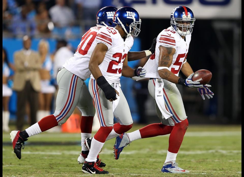 Michael Boley #59 of the New York Giants celebrates with teammates after making an interception against the Carolina Panthers during their game at Bank of America Stadium on September 20, 2012 in Charlotte, North Carolina.  