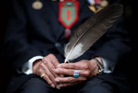 Charles Norman Shay, 94, a Penobscot Native American Indian WWII veteran, poses holding an eagle feather as he attends an interview with Reuters in Bretteville l'Orgueilleuse