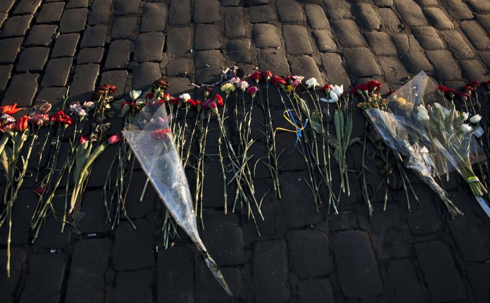 Flowers placed by people in memory of those who died in late February's clashes are lit by the early morning sun in Kiev's Independence Square, Ukraine, Tuesday, March 11, 2014. (AP Photo/David Azia)