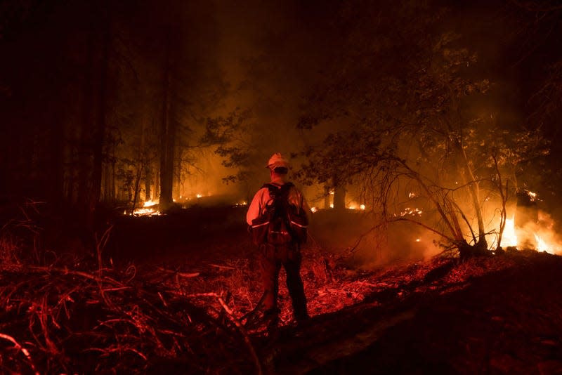 A firefighter battles flames during the Dixie Fire in Genesee, California, U.S., on Saturday, Aug. 21, 2021. The Dixie Fire grew overnight by nearly 10,000 acres, to 714,219 acres.