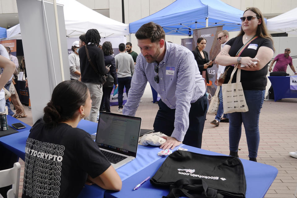 Hannah Niapas talks to Rodrigo Zuniga about job opportunities at Blockchain.com, during the Venture Miami Tech Hiring Fair Thursday, April 14, 2022, in Miami. America’s employers added 428,000 jobs in April, extending a streak of solid hiring that has defied punishing inflation, chronic supply shortages, the Russian war against Ukraine and much higher borrowing costs. (AP Photo/Marta Lavandier)