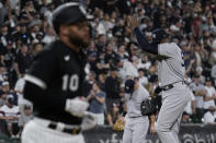 New York Yankees relief pitcher Aroldis Chapman, right, wipes his face as Chicago White Sox's Yoan Moncada (10) heads to first base during the ninth inning of a baseball game in Chicago, Saturday, May 14, 2022. (AP Photo/Nam Y. Huh)