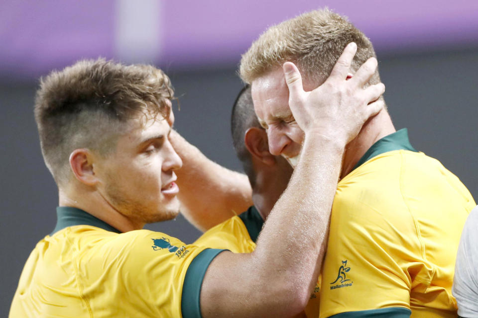 Australia's Reece Hodge, right, is congratulated by teammates after scoring a try during the Rugby World Cup Pool D game at Sapporo Dome between Australia and Fiji in Sapporo, northern Japan, Saturday, Sept. 21, 2019. (Naoya Osato/Kyodo News via AP)