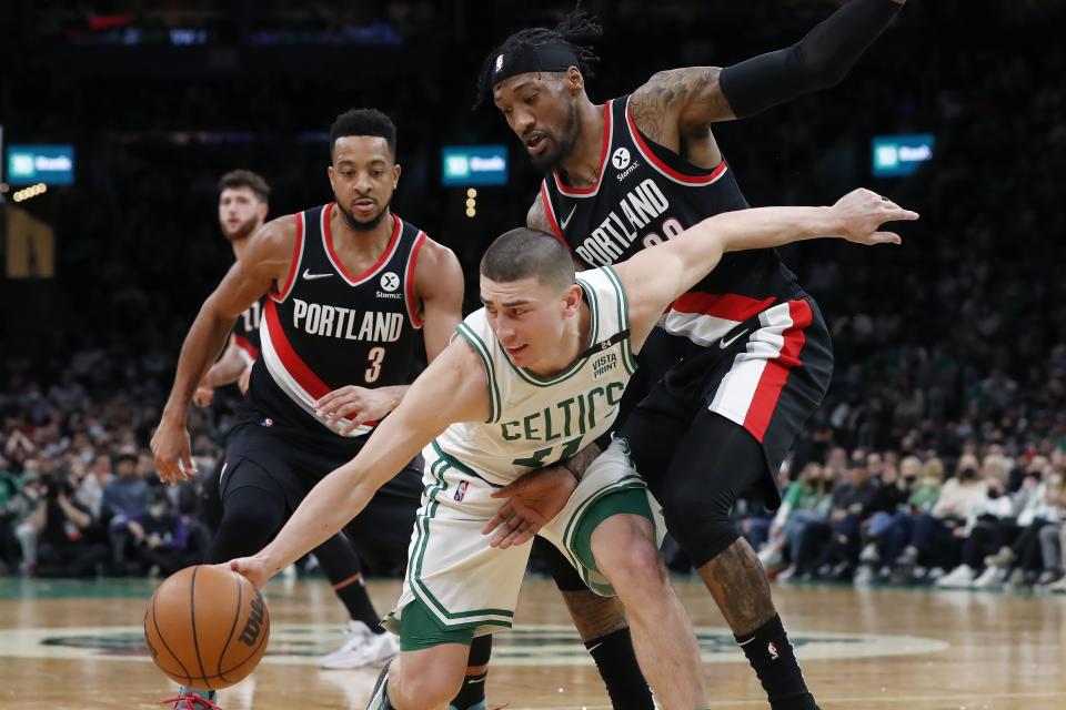 Boston Celtics' Payton Pritchard (11) struggles to control the ball against Portland Trail Blazers' CJ McCollum (3) and Robert Covington (33) during the second half of an NBA basketball game, Friday, Jan. 21, 2022, in Boston. (AP Photo/Michael Dwyer)