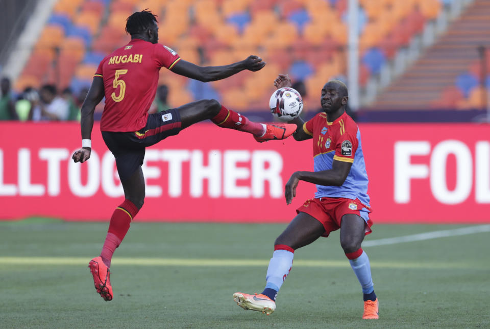 Uganda's Bevis Kristofer Kizito Mugabi clears the ball in front of DR Congo's Yannik Yala Bolasie during the African Cup of Nations group A soccer match between DR Congo and Uganda at Cairo International Stadium in Cairo, Egypt, Saturday, June 22, 2019. (AP Photo/Hassan Ammar)