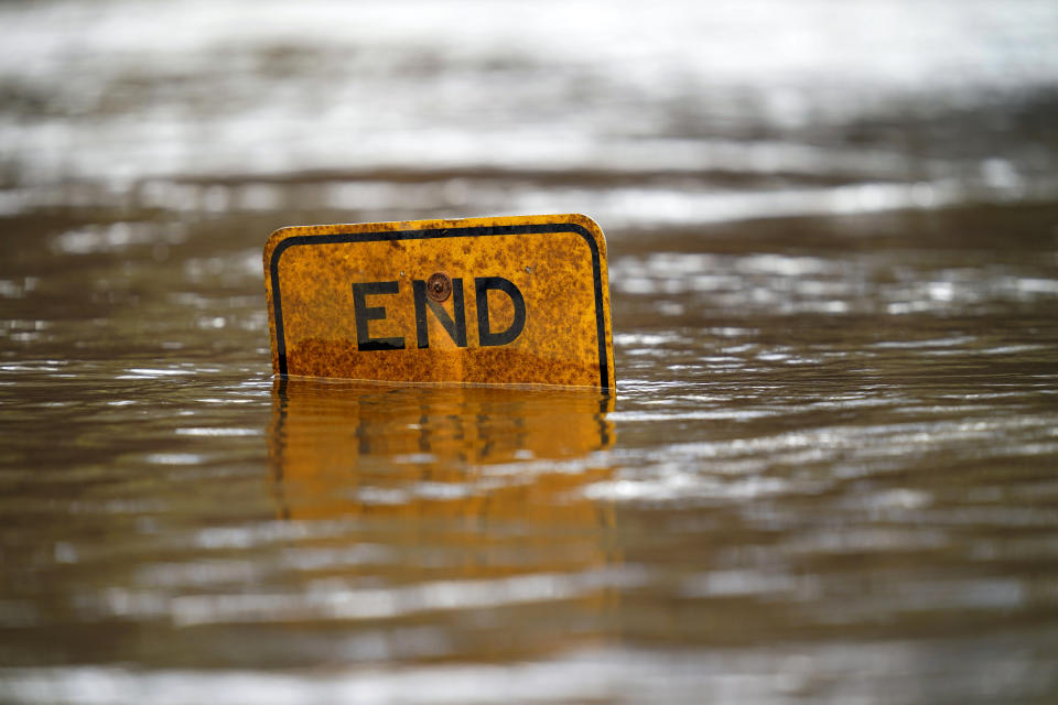 A boat ramp sign is submerged in the Tar River as it rises following a heavy rain in Princeville, N.C., Thursday, March 17, 2022. The river continues to be a threat to the small community nestled in the flood plain of the Tar River. (AP Photo/Gerry Broome)