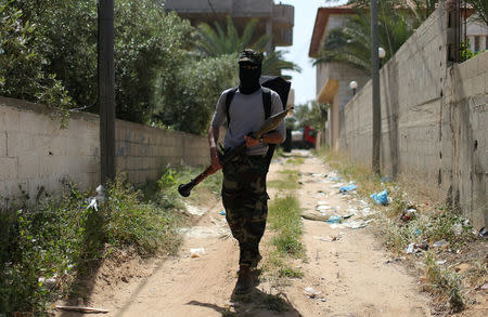 A member of Palestinian security forces loyal to Hamas takes up position during an operation to arrest the main suspect in an assassination attempt against Palestinian Prime Minister Rami Hamdallah, in the central Gaza Strip March 22, 2018. REUTERS/Ibraheem Abu Mustafa