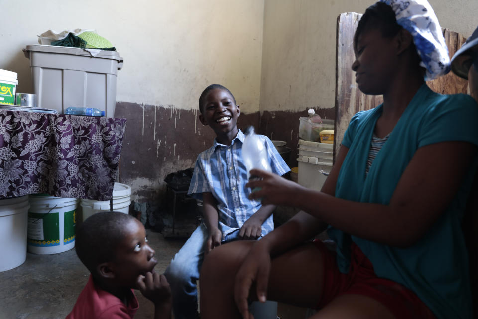 Woodberson Seide laughs as he plays with his step-sister Nayanka at the church where they live after drumming practice in the Delmas 32 neighborhood of Port-au-Prince, Haiti, Saturday, Sept. 23, 2023. Woodberson Seide's family sleeps on the floor of a church, something they've done since losing their home to gangs. (AP Photo/Odelyn Joseph)