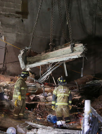 Mexican firefighters remove a platform as they search for survivors in a collapsed building after an earthquake in Mexico City, Mexico September 24, 2017. REUTERS/Henry Romero