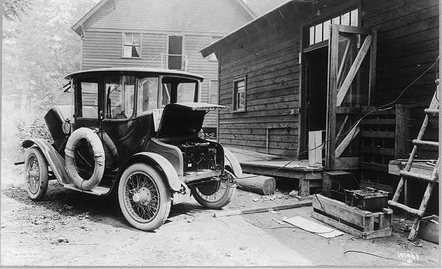 Automóvil eléctrico de 1919 en una estación de recarga (imagen vía The Library of Congress)