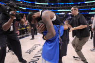 Dallas Mavericks' Kyrie Irving hugs his child after the team's win in Game 6 of an NBA basketball second-round playoff series against the Oklahoma City Thunder Saturday, May 18, 2024, in Dallas. (AP Photo/Tony Gutierrez)