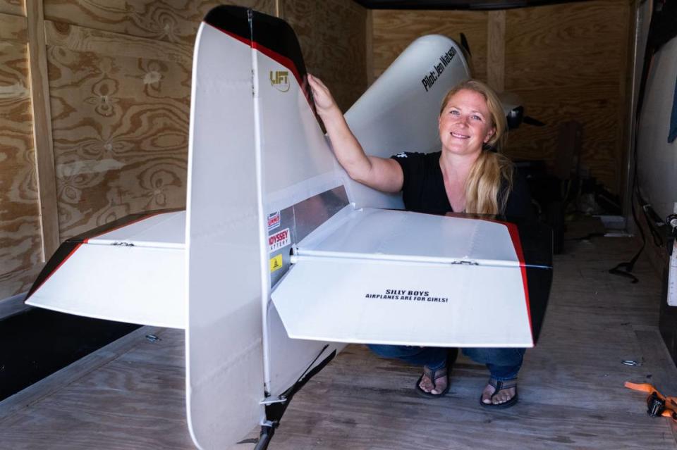 Racing pilot Jen Watson of Wilton poses with part of her plane Black Jack, disassembled for transportation by trailer, at her home in Wilton on Wednesday, Sept. 6, 2023. Watson will be competing for the first time in the Reno Air Races, which will be held for the last time starting Sept. 13. “Silly boys – Airplanes are for girls,” reads the text on part of the tail section.