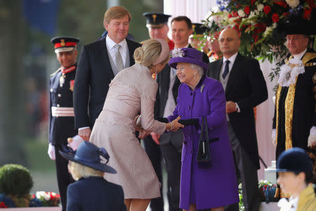 Britain's Queen Elizabeth greets Queen Maxima of the Netherlands as King Willem-Alexander looks on during a ceremonial welcome at the start of a state visit at Horse Guards Parade, in London, Britain October 23, 2018. Christopher Furlong/Pool via REUTERS