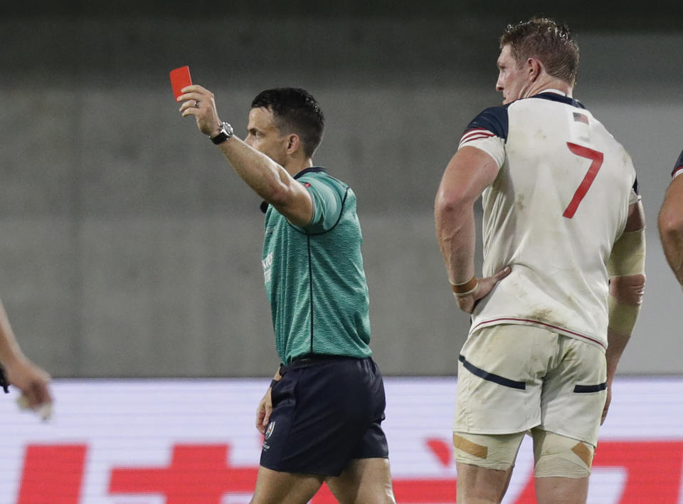 Referee Nick Berry shows a red card to United States' John Quill, right, during the Rugby World Cup Pool C game at Kobe Misaki Stadium, between England and the United States in Kobe, Japan, Thursday, Sept. 26, 2019. (AP Photo/Aaron Favila)