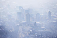 FILE - In this Jan. 18, 2017, file photo, smog covers Salt Lake City as an inversion lingers. When it comes to their views on climate change, Americans are looking at natural disasters and their local weather, according to a new poll. (Ravell Call/The Deseret News via AP, File)