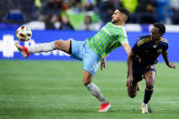Seattle Sounders midfielder Cristian Roldan, left, receives the ball next to Vancouver Whitecaps forward Ali Ahmed during the second half of an MLS soccer match Saturday, April 20, 2024, in Seattle. The Whitecaps won 2-0. (AP Photo/Lindsey Wasson)