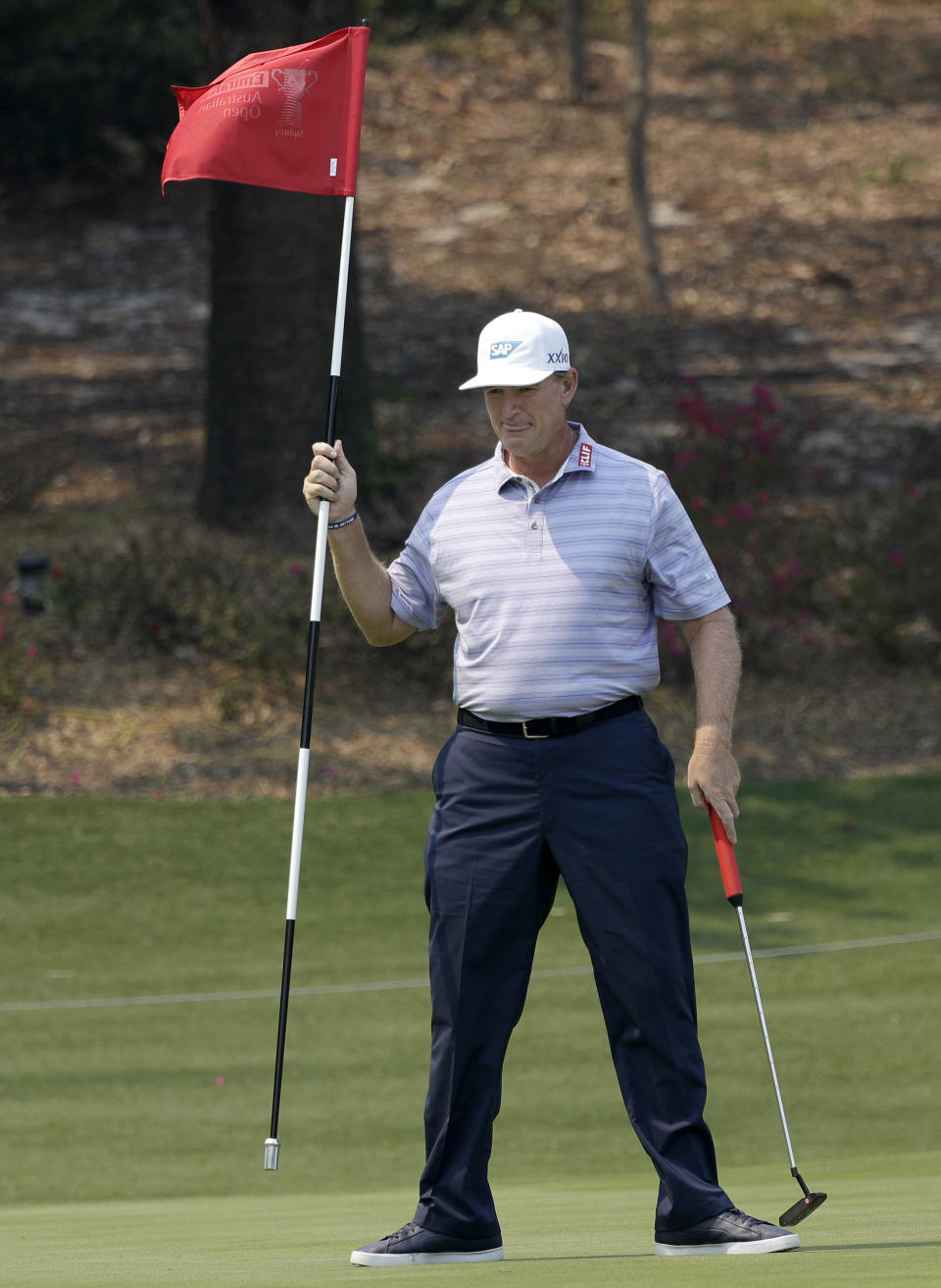 South Africa's Ernie Els plays removes the flag on the first hole during the Australian Open Golf Pro-AM in Sydney, Wednesday, Dec. 4, 2019. The Australian Open begins Thursday. (AP Photo/Rick Rycroft)