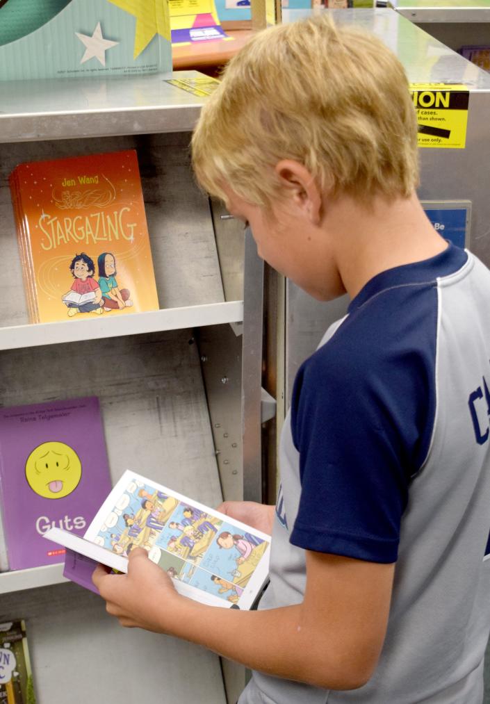 En la Feria del Libro Scholastic en la Escuela Primaria West Bay, los estudiantes tenían más de 1,000 libros para elegir.  Todos pueden elegir dos libros gratis.