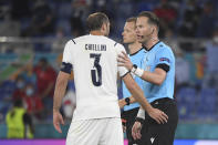 Italy's Giorgio Chiellini, left speaks with referee Danny Makkelie during the Euro 2020 soccer championship group A match between Italy and Turkey at the Olympic stadium in Rome, Friday, June 11, 2021. (Alberto Lingria/Pool Photo via AP)