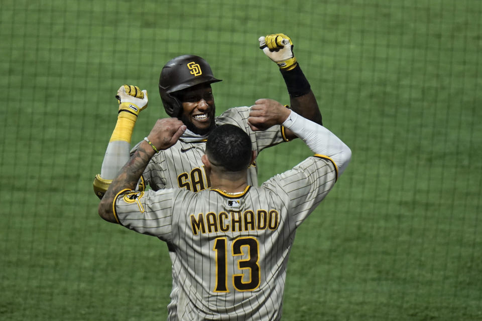 San Diego Padres' Jurickson Profar, top, celebrates his two-run home run with Manny Machado during the fourth inning of a baseball game against the Los Angeles Angels, Wednesday, Sept. 2, 2020, in Anaheim, Calif. (AP Photo/Jae C. Hong)
