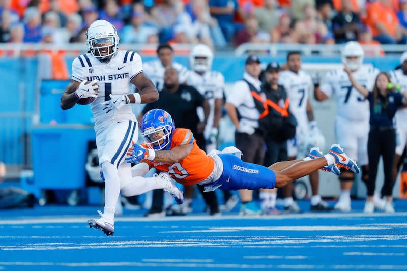 Utah State wide receiver Jalen Royals (1) runs through a diving tackle attempt by Boise State safety Ty Benefield (0) for a 59-yard touchdown reception in the first half of an NCAA college football game, Saturday, Oct. 5, 2024, in Boise, Idaho. . (AP Photo/Steve Conner) | Steve Conner