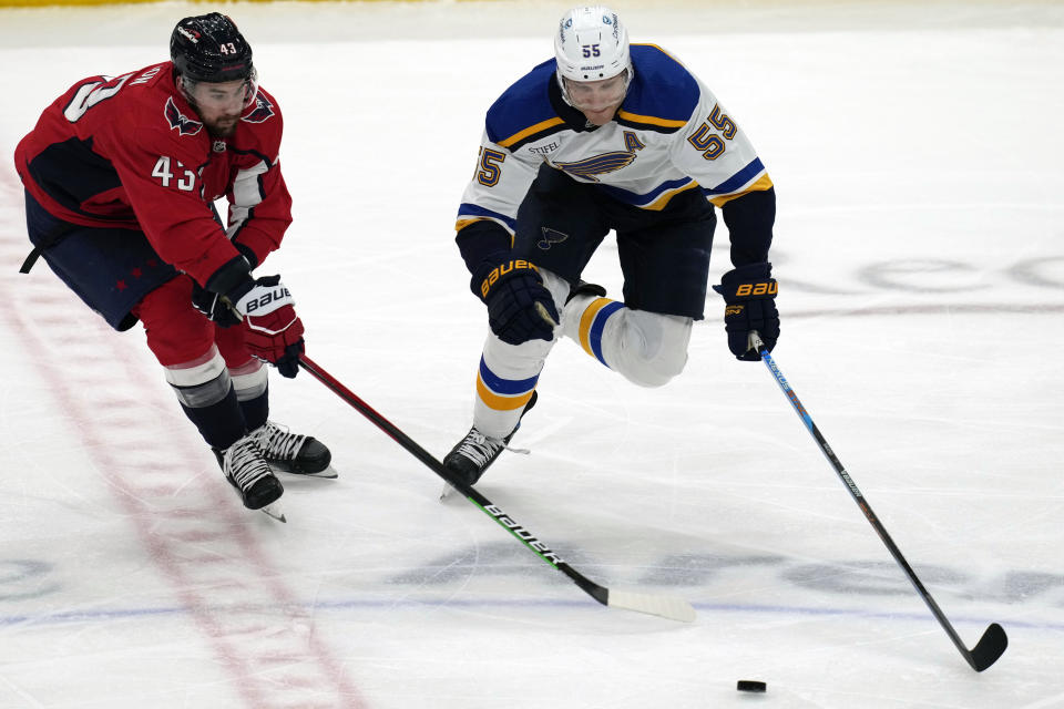 Washington Capitals right wing Tom Wilson (43) and St. Louis Blues defenseman Colton Parayko (55) chase the puck during the second period of an NHL hockey game Friday, March 17, 2023, in Washington. (AP Photo/Carolyn Kaster)