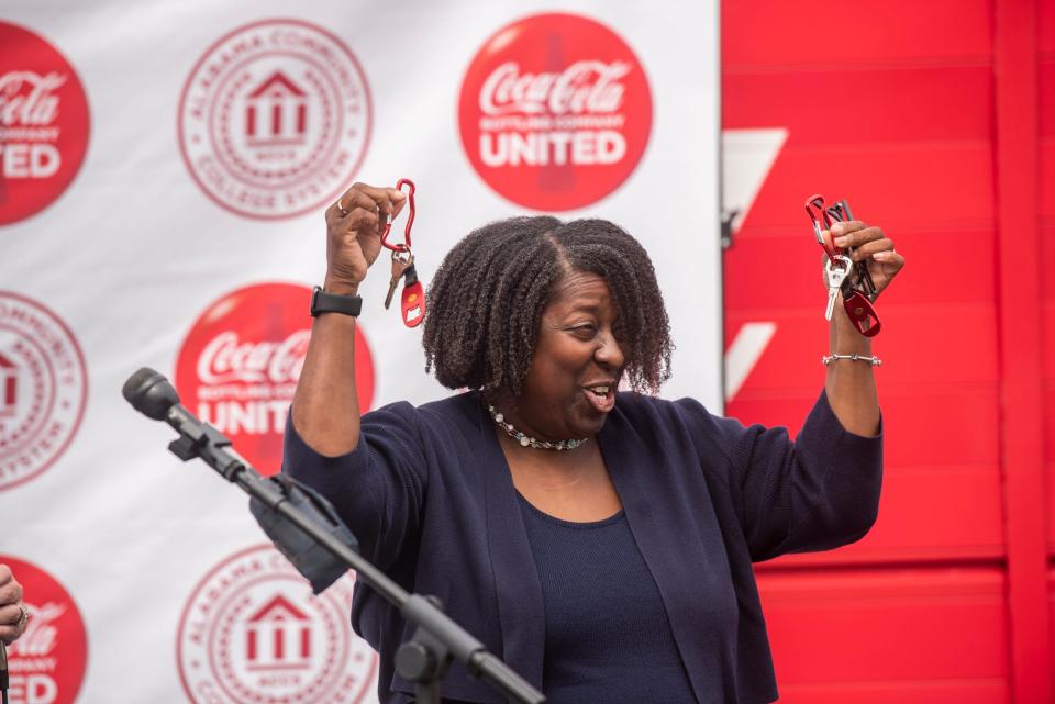 Susan Price Vice Chancellor of Alabama Community College System accepts the staged keys as Coca-Cola United donates trucks to Trenholm State Community College for driving classes in Montgomery, Ala., on Tuesday, May 9, 2023.