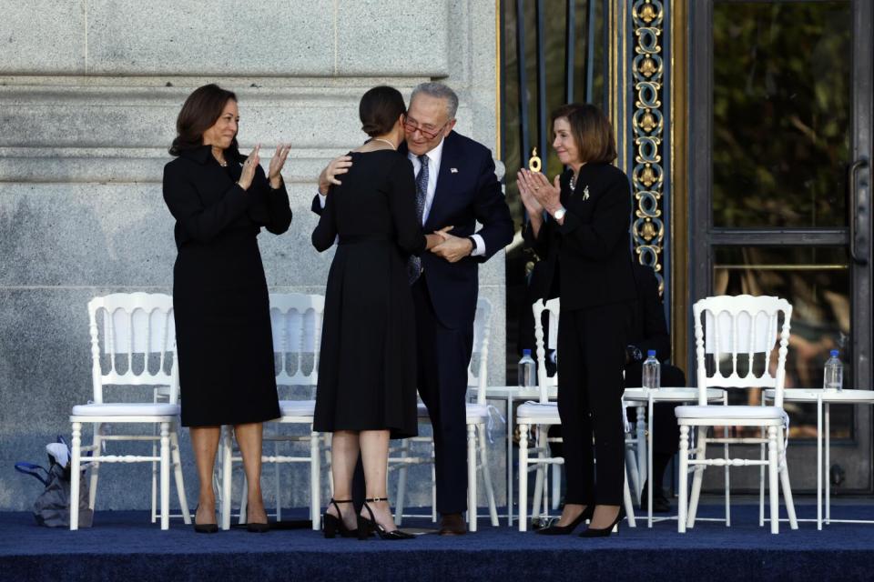 U.S. Senate Majority Leader Chuck Schumer, center, hugs Eileen Mariano, granddaughter of Sen. Feinstein