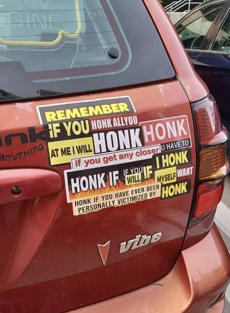 Bumper covered in various stickers telling other drivers to honk if they need anything, if they’ve been personally victimized by honking, and to honk if they get closer
