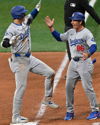 Shohei Ohtani (à gauche) avec son coach Clayton McCullough, lors du match entre les Los Angeles Dodgers et les San Diego Padres à Séoul, le 20 mars 2024.. PHOTO JUNG YEON-JE/AFP