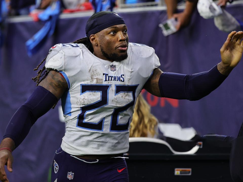 Derrick Henry high-fives fans while running off the field after a Titans game.