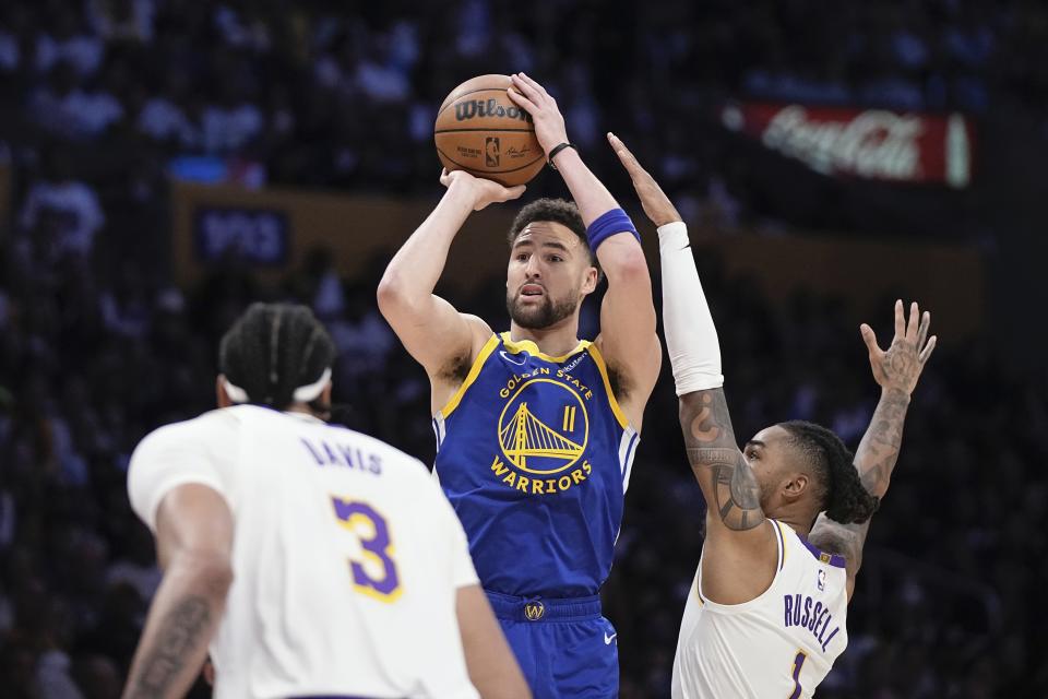 Golden State Warriors guard Klay Thompson, center, shoots as Los Angeles Lakers guard D'Angelo Russell, right and forward Anthony Davis defend during the first half in Game 3 of an NBA basketball Western Conference semifinal Saturday, May 6, 2023, in Los Angeles. (AP Photo/Mark J. Terrill)