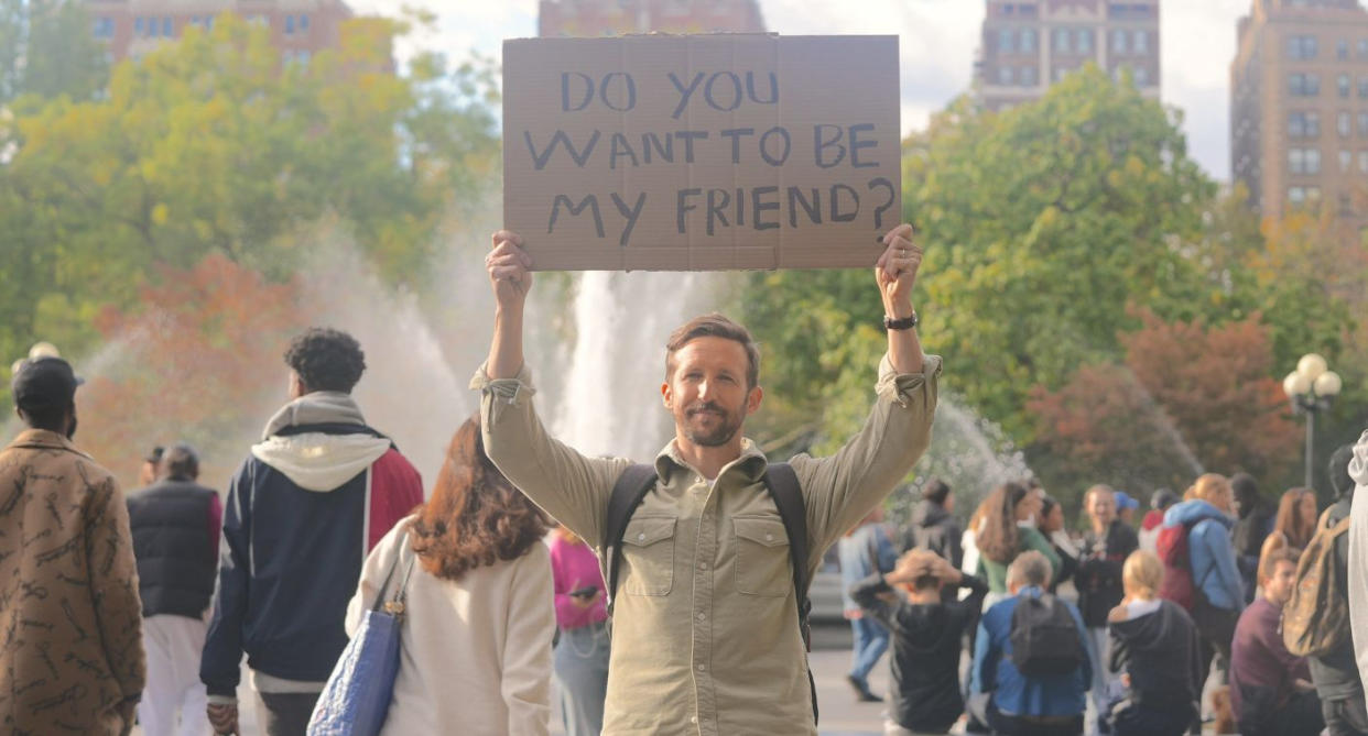 In a social experiment last year, Lee Thompson stood in Washington Square Park, New York, holding up a sign saying, 'Do you want to be my friend?' (Supplied)