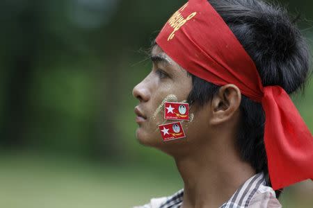 A man is seen with National League for Democracy (NLD) party flag stickers during a NLD campaign rally in Taikkyi township, Yangon Division, Myanmar October 10, 2015. REUTERS/Soe Zeya Tun