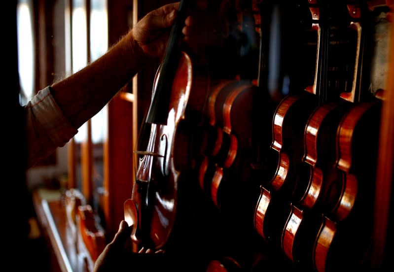 Svetozar Bogdanovski, an internationally recognised self-taught craftsman from Veles, holds a replica of an Antonio Stradivari's violin, at his shop in Veles