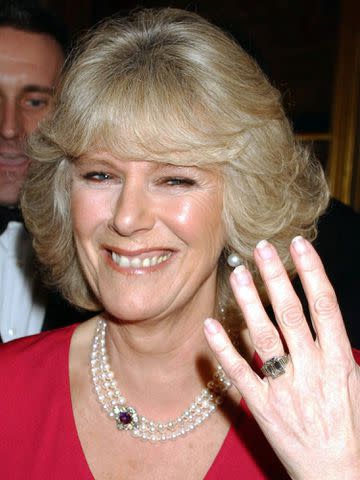 <p>Anwar Hussein/WireImage</p> Camilla Parker Bowles shows her engagement ring when she arrives for a party at Windsor Castle after announcing her engagement on February 10, 2005.