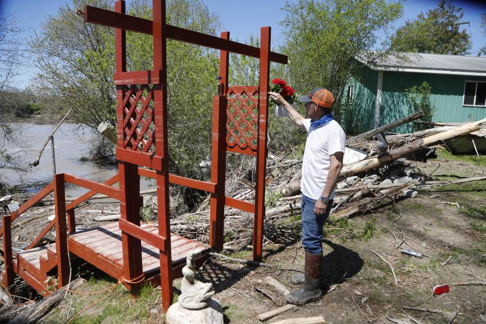 Dan Dionne points to where the water level was next looks to his home, Wednesday, May 20, 2020, in Edenville, Mich. Some people living along two mid-Michigan lakes and parts of a river have been evacuated following several days of heavy rain that produced flooding and put pressure on dams in the area returned to the area to survey the damage. (AP Photo/Carlos Osorio)