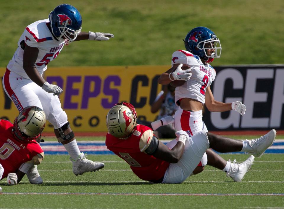 Cooper's Cameron Herron, right, is tackled by Lubbock Coronado's DeAundrew Lewi on Sept. 16 at Lowrey Field in Lubbock. Cooper won 33-28.